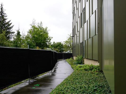 path between Buildings 13 and 10, with the Building 10 side fenced